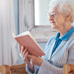 Mujer mayor leyendo, rutina diaria de persona mayor.