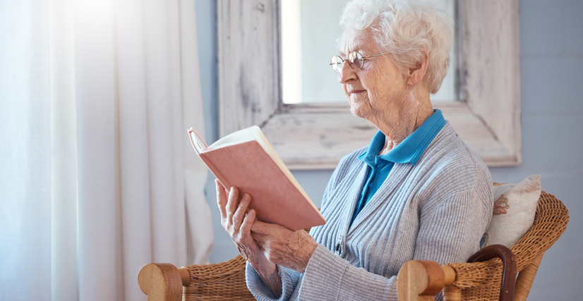 Mujer mayor leyendo, rutina diaria de persona mayor.