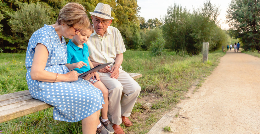Unos abuelos cuidando de su nieto en el parque.